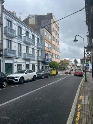 a street with cars parked on the side of the road at Apartamento Casa Cruceiro in Arzúa