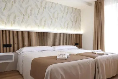 two beds in a bedroom with two towels on them at Apartamento Casa Cruceiro in Arzúa