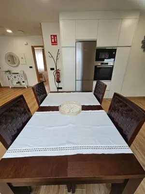 a kitchen with a table with a white table cloth at Apartamento Casa Cruceiro in Arzúa