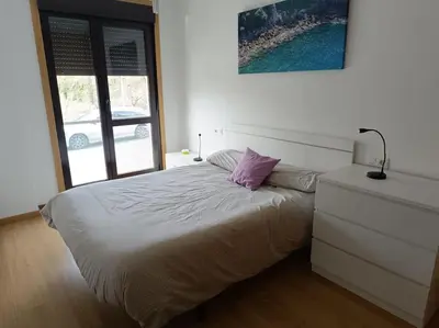 a bedroom with a bed with a purple pillow on it at Mi Morada - Apartamento in Lalín