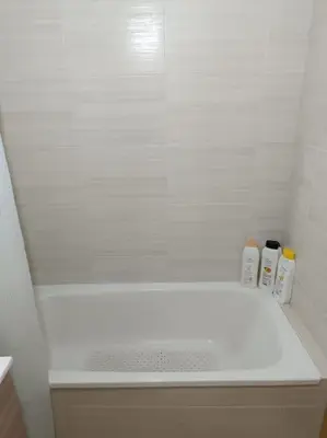 a white bath tub with two shampoo bottles on it at Mi Morada - Apartamento in Lalín