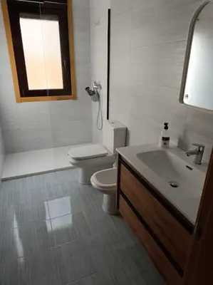 a white bathroom with a toilet and a sink at Mi Morada - Apartamento in Lalín