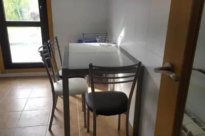 a table and chairs in a room with a window at Mi Morada - Apartamento in Lalín