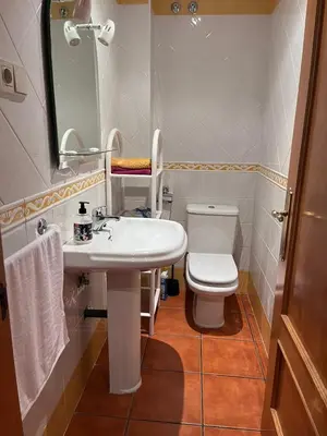 a bathroom with a white sink and a toilet at O xualtar Océano 2 in Villadaíde