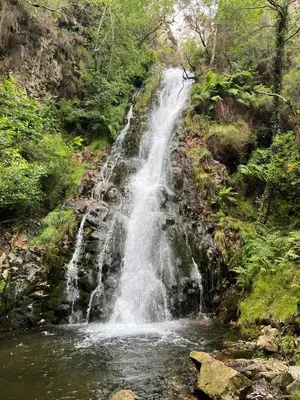 a waterfall in the middle of a river at O xualtar Océano 2 in Villadaíde