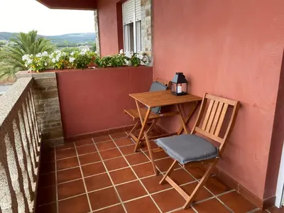 a small table and chairs on a balcony at Casa das Indias in Ribadeo