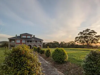 a large house in a field with bushes at Casa das Indias in Ribadeo