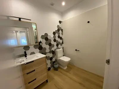 a bathroom with a toilet and a sink and a mirror at Casa das Indias in Ribadeo