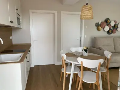 a kitchen and living room with a table and chairs at Casa das Indias in Ribadeo