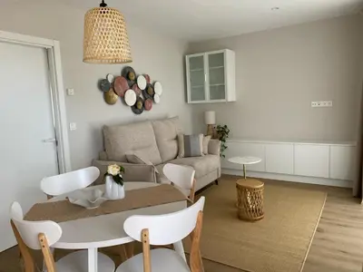 a living room with a couch and a table and chairs at Casa das Indias in Ribadeo