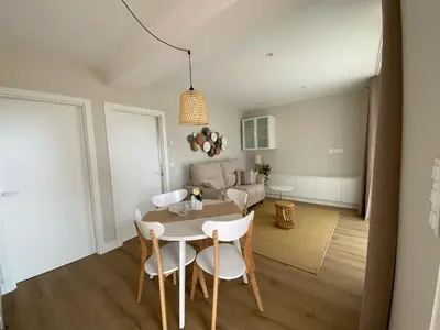 a dining room and living room with a table and chairs at Casa das Indias in Ribadeo