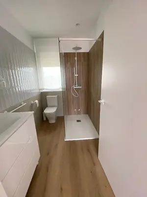 a bathroom with a toilet and a glass shower door at Casa das Indias in Ribadeo