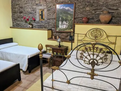 a bedroom with two beds and a stone wall at O Val de Vilaboa in Bóveda