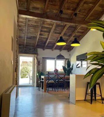 a kitchen and dining room with wooden ceilings and a table at CASA DO XASTRE in Arnego