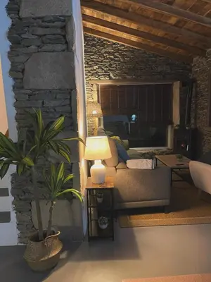 a living room with a couch and a table with a plant at CASA DO XASTRE in Arnego