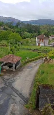 a dirt road with a building on the side of a field at Casa o Pontillón in Rabiño