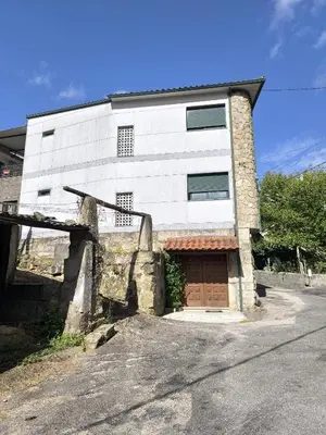 a white building with a door in front of it at Casa o Pontillón in Rabiño