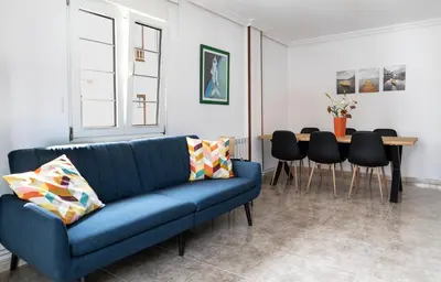 a living room with a blue couch and a table at Piso Turístico Las Nisas I in Puerto de Vega