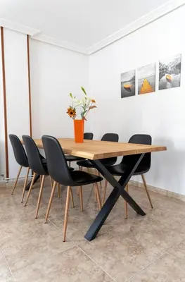 a wooden table and chairs in a room at Piso Turístico Las Nisas I in Puerto de Vega