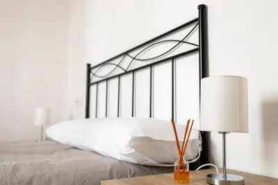 a bedroom with a white bed with a black frame at Piso Turístico Las Nisas I in Puerto de Vega