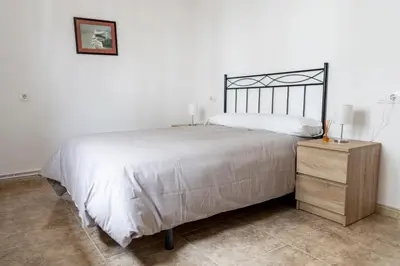 a bedroom with a large bed and a night stand at Piso Turístico Las Nisas I in Puerto de Vega