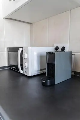 a microwave oven sitting on a counter in a kitchen at Piso Turístico Las Nisas I in Puerto de Vega