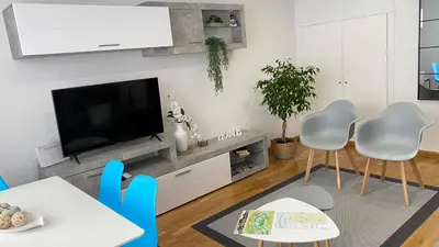 a living room with a tv and a table and chairs at Apartamento Ainaran Confortable apartamento en el centro de Orense in Ourense