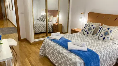 a bedroom with a large bed with towels on it at Apartamento Ainaran Confortable apartamento en el centro de Orense in Ourense