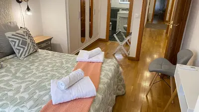 a room with a bed with towels on it at Apartamento Ainaran Confortable apartamento en el centro de Orense in Ourense