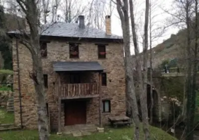 an old stone house in the middle of trees at O Recuncho de Doiras in Ferreiravedés