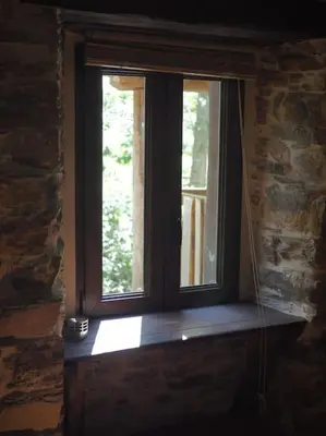a window in a room with a brick wall at O Recuncho de Doiras in Ferreiravedés