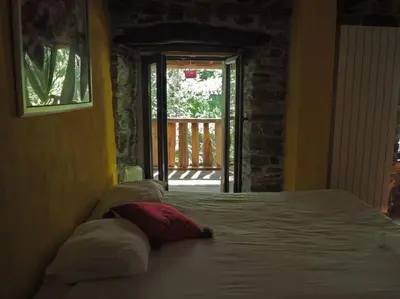 a bedroom with a bed with pillows and a window at O Recuncho de Doiras in Ferreiravedés