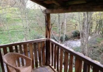 a wooden porch with a chair sitting on a deck at O Recuncho de Doiras in Ferreiravedés