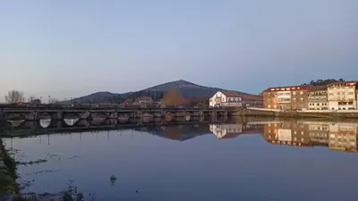 a bridge over a body of water with buildings at Cesuresrooms2 in Puentecesures