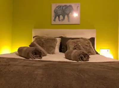 a bedroom with a bed and a yellow wall at Casa Quercus Galicia a 17 minutos de Compostela! in A Estrada