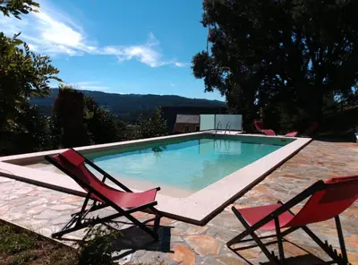 a porch with wicker chairs and a swing at Casa Quercus Galicia a 17 minutos de Compostela! in A Estrada