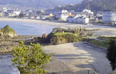 a view of a beach with a city in the background at Mariña in Viveiro