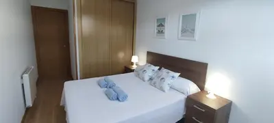 a bedroom with a white bed with blue pillows at Mariña in Viveiro