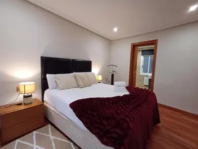 a bedroom with a large bed and two lamps at Bedoya - Amplio y moderno piso en pleno centro de Ourense in Ourense