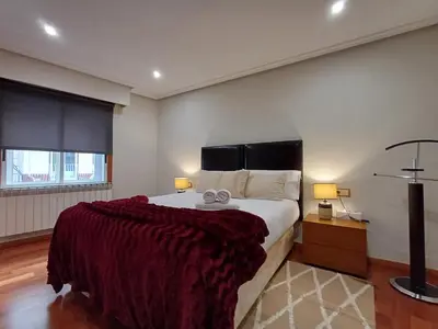 a bedroom with a large bed and two lamps at Bedoya - Amplio y moderno piso en pleno centro de Ourense in Ourense