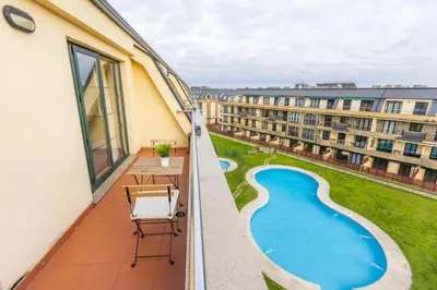 an apartment balcony with a view of a swimming pool at Costa SPA Ático de lujo - Playa de las Catedrales in San Miguel de Reinante