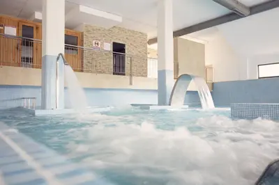 a large swimming pool with a water fountain at Costa SPA Ático de lujo - Playa de las Catedrales in San Miguel de Reinante