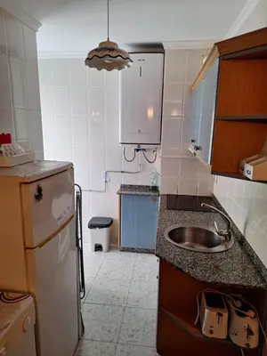 a small kitchen with a sink and a refrigerator at Vivienda PLAYA DE ALTAR in Barreiros