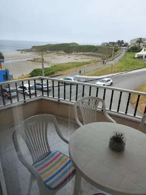 a table and chairs on a balcony with a view of the beach at Vivienda PLAYA DE ALTAR in Barreiros