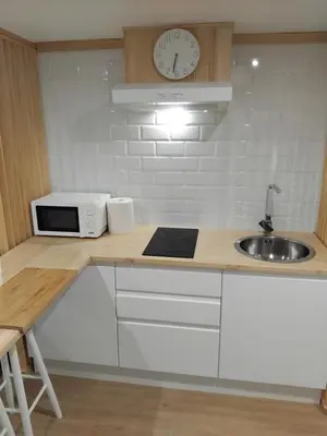 a kitchen with a counter with a sink and a clock at Sita in A Estrada