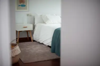 a bedroom with a white bed and a night stand at Bahía de Miño in Miño
