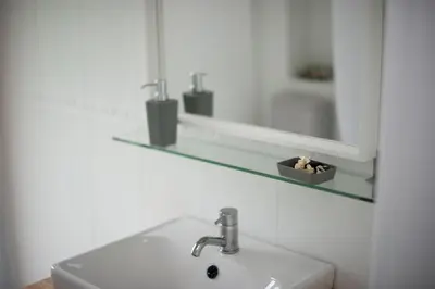 a white bathroom with a sink and a mirror at Bahía de Miño in Miño