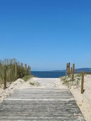 a wooden path to the beach with the ocean at Bahía de Miño in Miño
