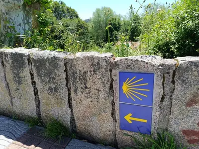 a sign on the side of a stone wall at Bahía de Miño in Miño