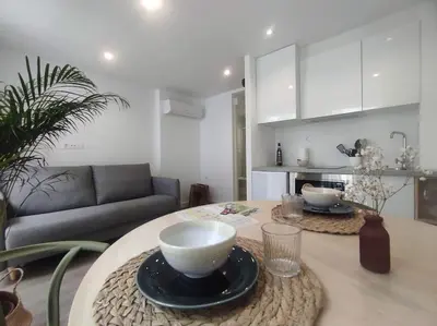 a kitchen and living room with a table with bowls on it at Lepanto2 - En el centro gastronómico y junto a la catedral in Ourense